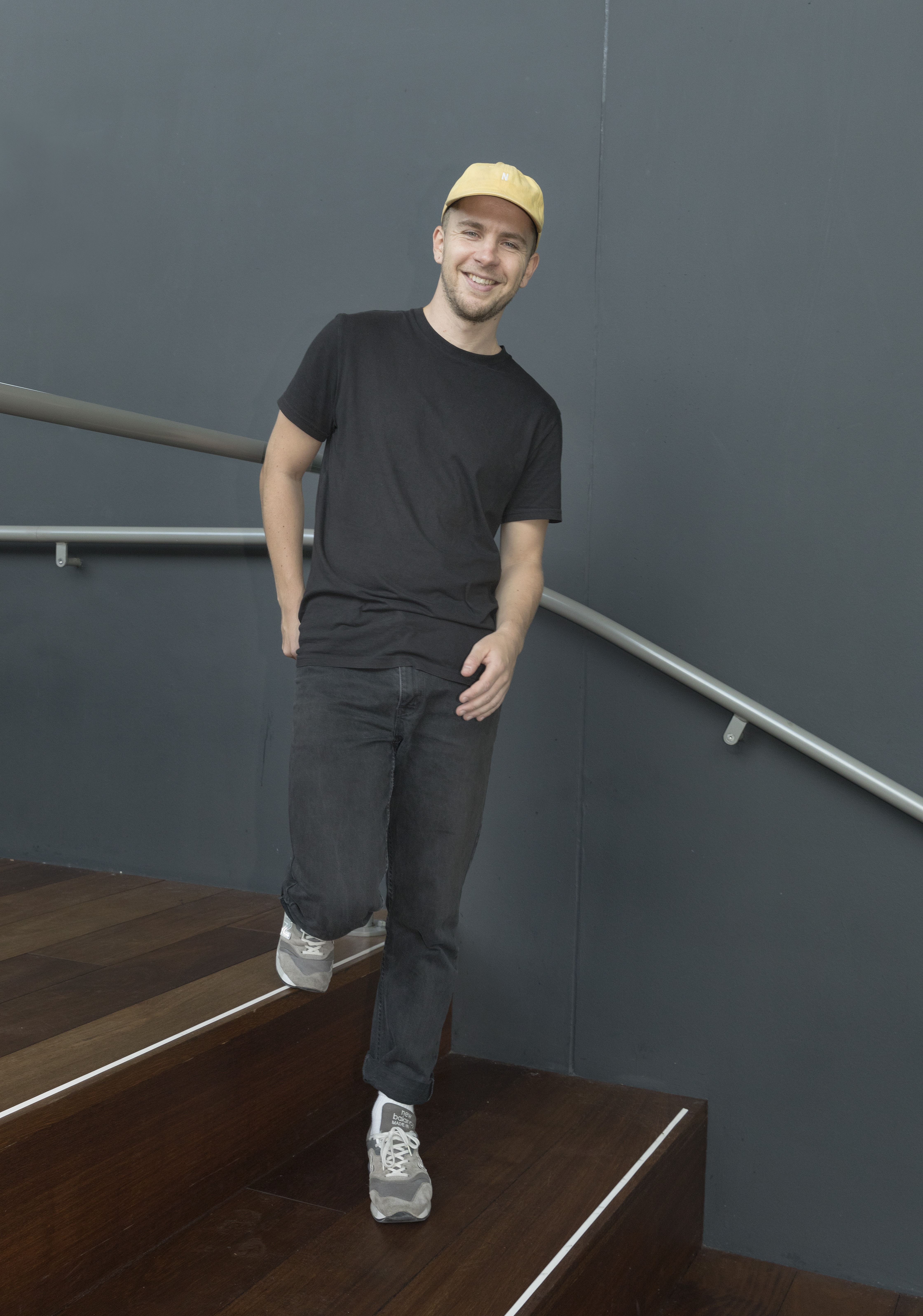 Lennard Kok poseert op de trap waar zijn kunstwerk aangebracht gaat worden